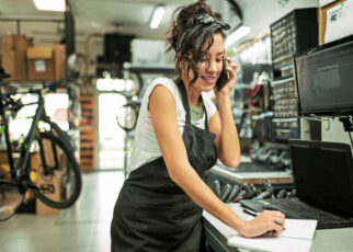 beautiful young female bicycle mechanic working on a customer bicycle